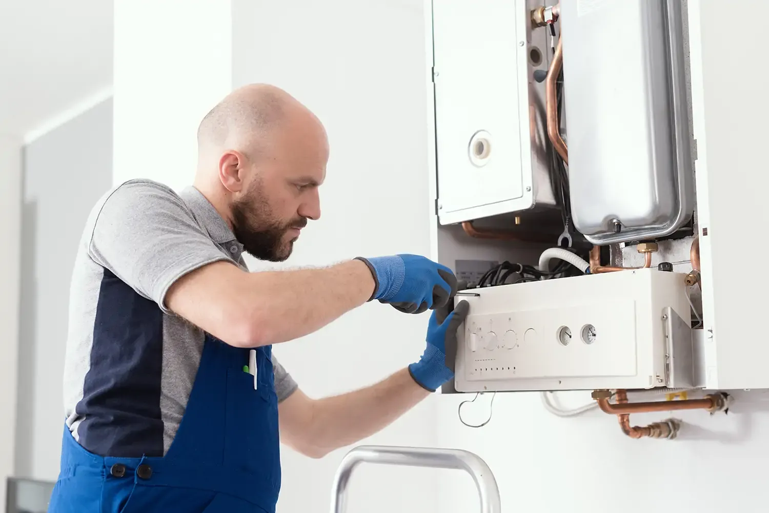 Gas engineer repairing a boiler to improve home heating efficiency and safety