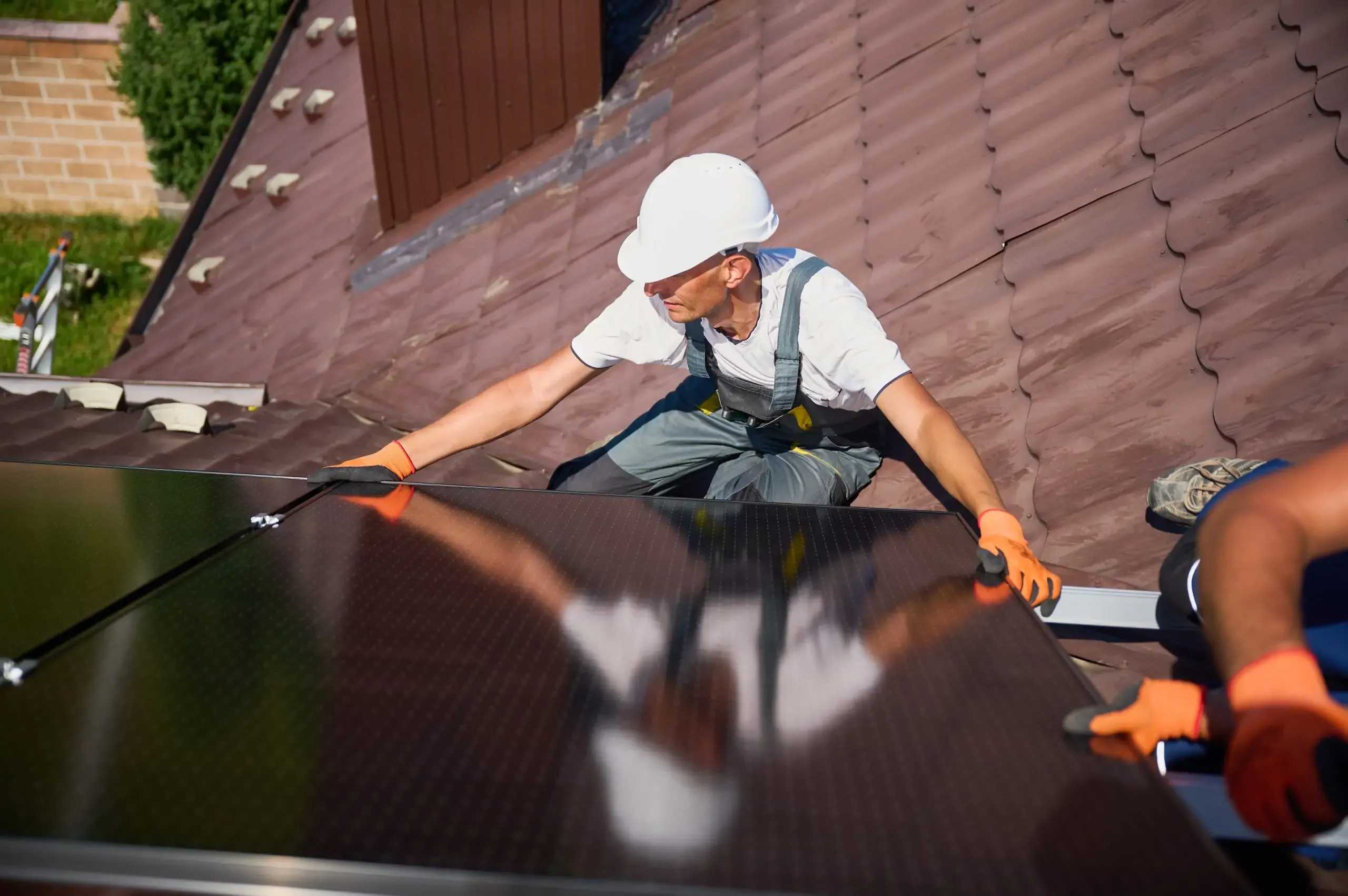 Workman aligning solar panels in preparation for installation as part of government-funded solar panel grants