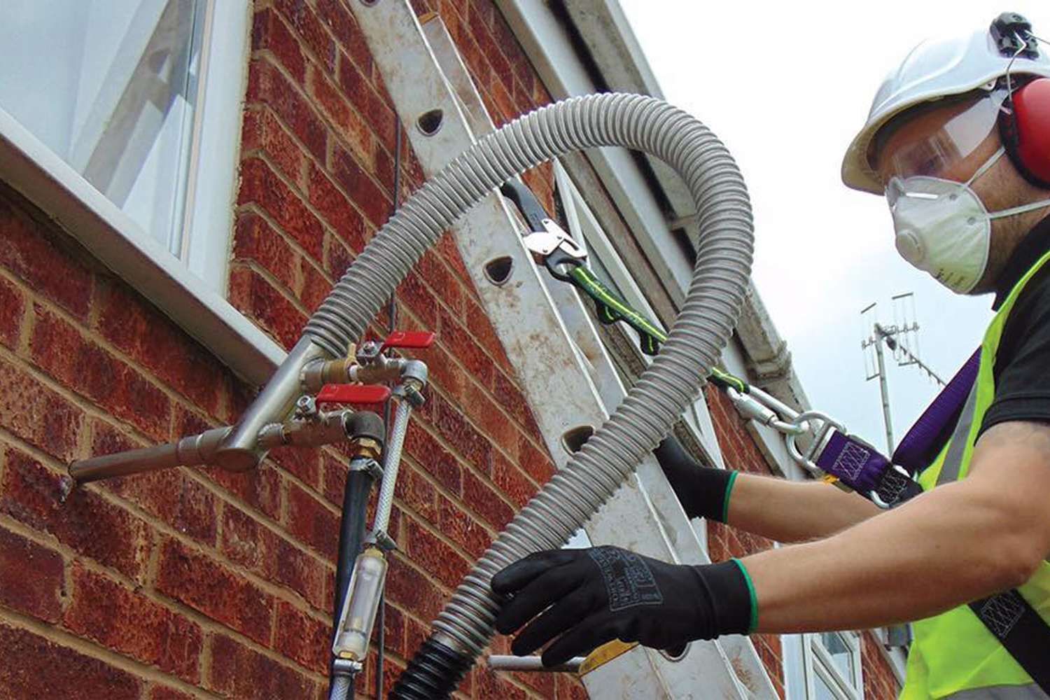 man pumping cavity wall with insulation